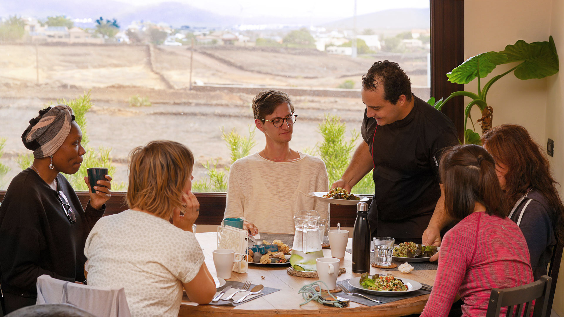 Villa Azul chef serving a vegan meal to five guests at a table in Fuerteventura