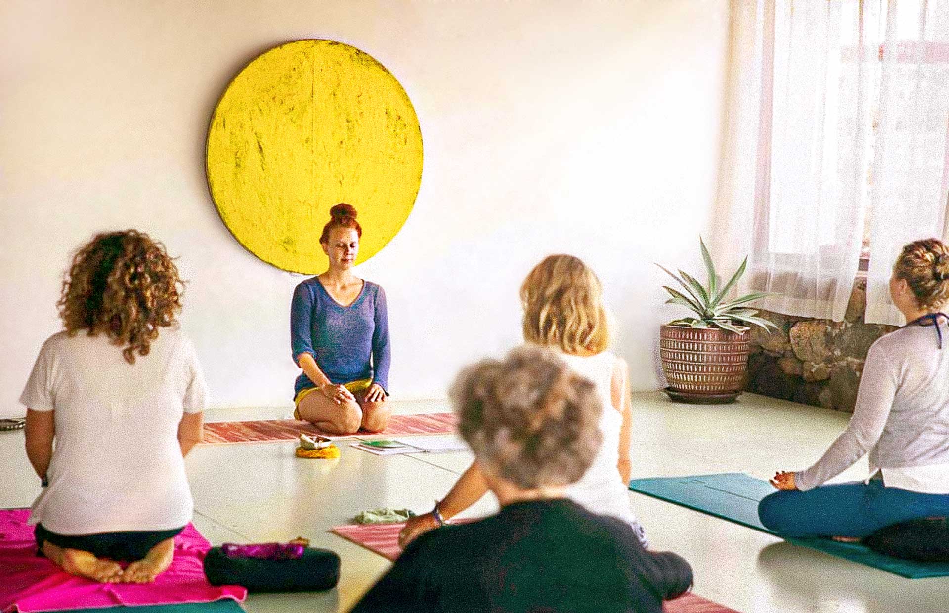 Yoga teacher guiding a meditation practice with students in the yoga shala at Villa Azul, Fuerteventura