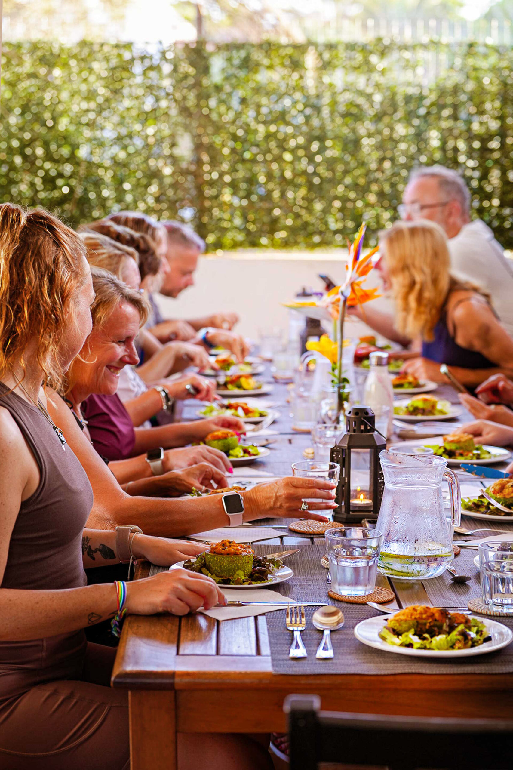 Group of twelve people sharing a meal around a large wooden table at Villa Azul, Fuerteventura
