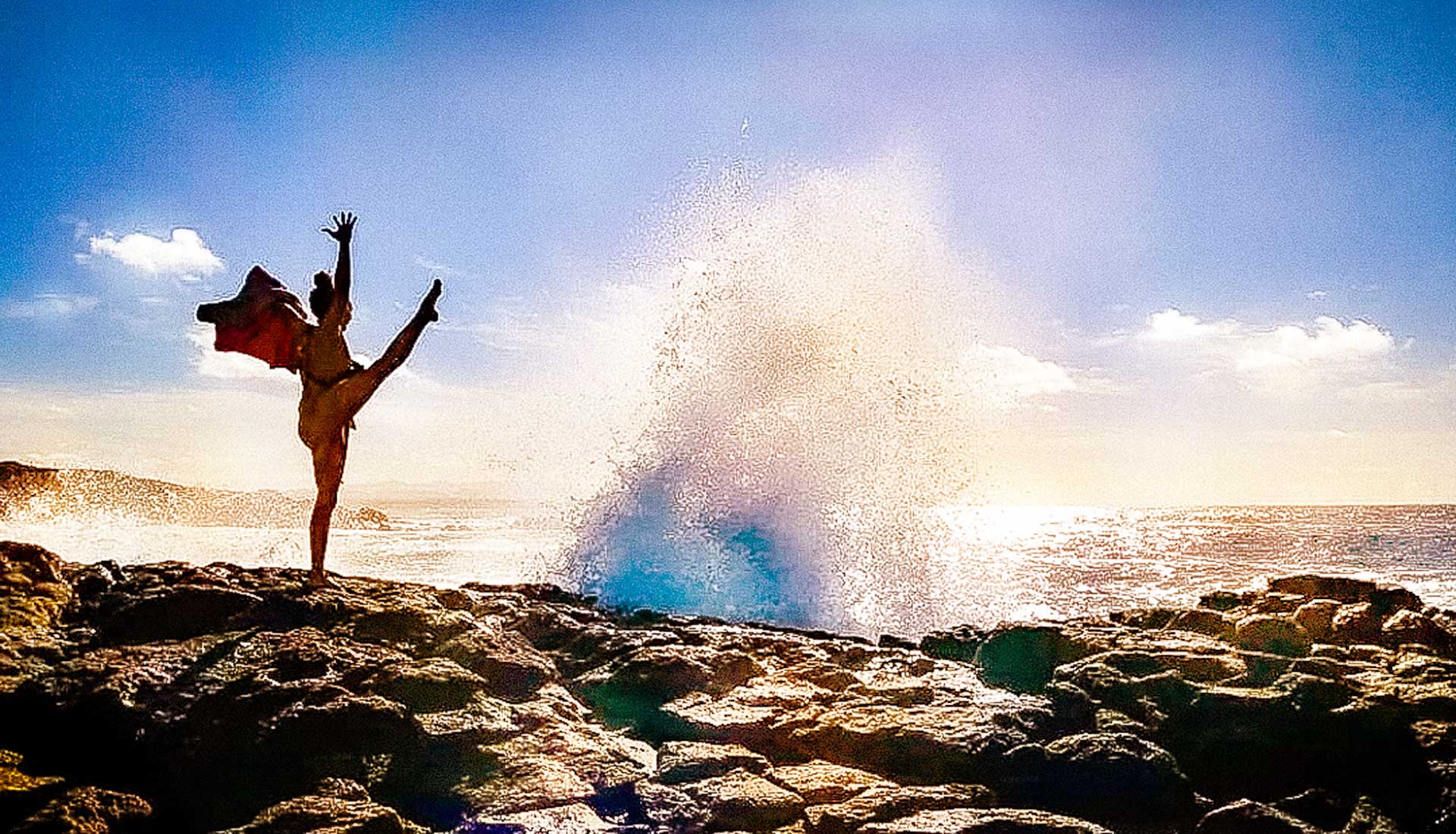 Woman practising a dynamic balancing yoga pose on a beach in Fuerteventura